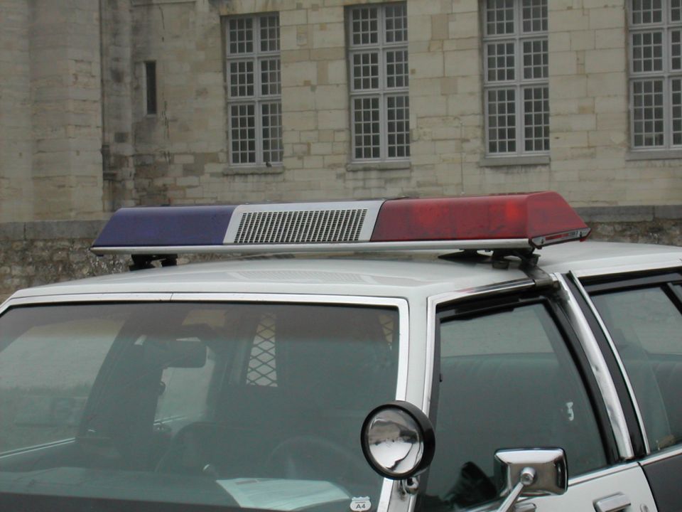 1991 Ford Crown Victoria police car with red and blue light bar on roof