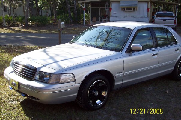 Silver 1998 Ford Crown Victoria sedan, front 3/4 view, with aftermarket black rims