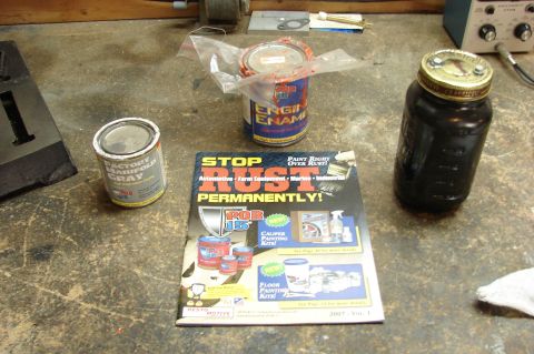 2004 Toyota Tacoma - Workbench scene with paint cans and a jar, alongside a 'Stop Rust Permanently' magazine.