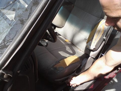 1995 Ford Taurus - The interior of a car shows a driver's seat with significant wear and tear on the upholstery.