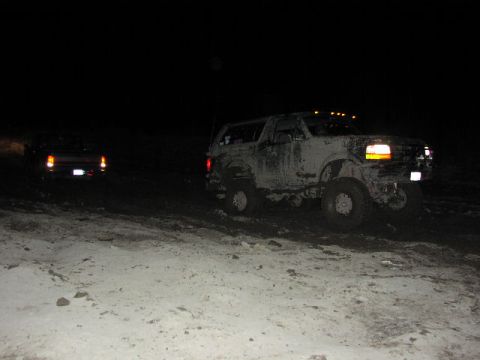 1981 Ford Bronco - Two vehicles are seen off-road at night, one is a mud-covered Ford Bronco.