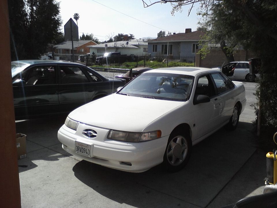 White 1995 Ford Taurus sedan, front 3/4 view. California license plate 3RVD943