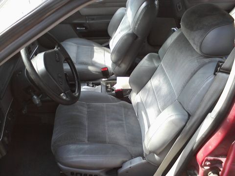 1995 Ford Taurus - The interior of a car features gray cloth and leather seats with a view of the steering wheel and dashboard.