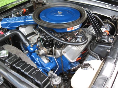 1968 Shelby GT500 - The engine bay of a 1968 Shelby GT500 shows a V8 engine with a blue air cleaner and valve covers.