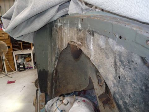 1969 Lincoln Continental - Detail of a vehicle's undercarriage, showing rust and wear on the frame and wheel well.