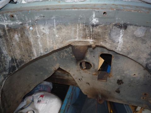 1969 Lincoln Continental - The underside of a vehicle shows significant rust and wear on its structural components.