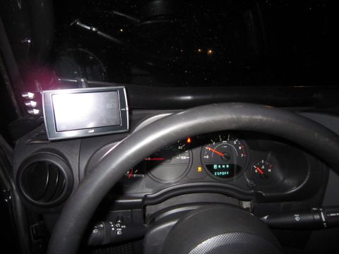 2008 Jeep Wrangler - The interior of a Jeep Wrangler shows a GPS unit mounted on the dashboard and the instrument cluster.