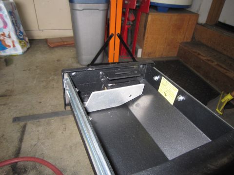 2008 Jeep Wrangler - A close-up view of a metal drawer slide mechanism, a yellow warning sticker attached to the side.