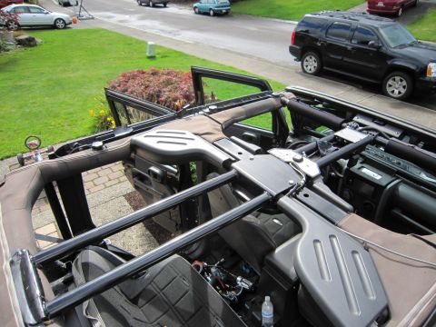2008 Jeep Wrangler - Looking down into a Jeep Wrangler with soft top, doors and roll-cage crossbars removed during disassembly, parked on a driveway.