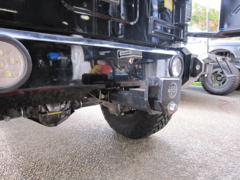 2008 Jeep Wrangler - Close-up of a vehicle's rear end, highlighting aftermarket bumper and differential components with another vehicle nearby.