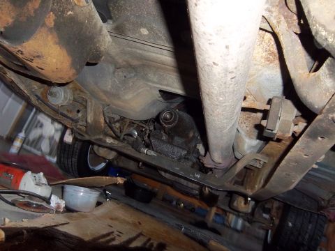 1989 Ford F-150 - This photo shows the underside of a vehicle, including its exhaust system and suspension parts, with tools nearby.