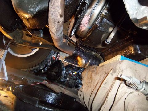 1989 Ford F-150 - The underside of a vehicle is shown, with parts removed for maintenance and significant oil leakage present.