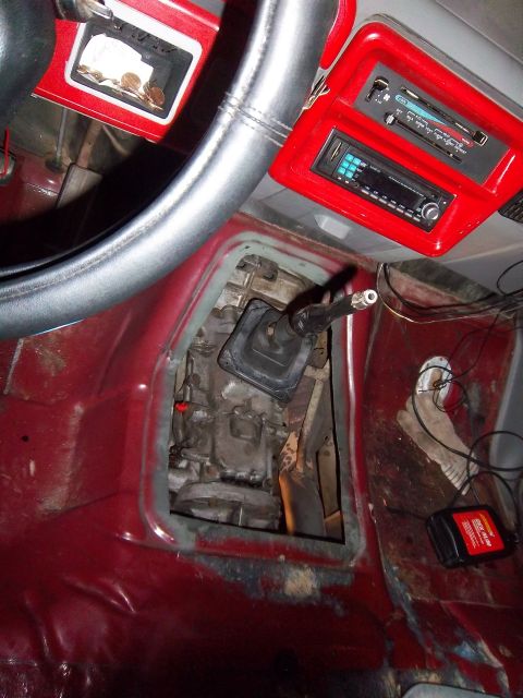 1989 Ford F-150 - Exposed transmission tunnel and dashboard of a truck, an aftermarket stereo system.