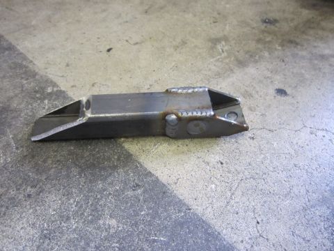 2008 Jeep Wrangler - A custom-fabricated metal bracket sits on a concrete surface, showing visible weld marks.