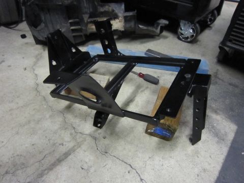 2008 Jeep Wrangler - A black dual battery tray is shown, supported by wooden blocks, with a screwdriver resting on it.