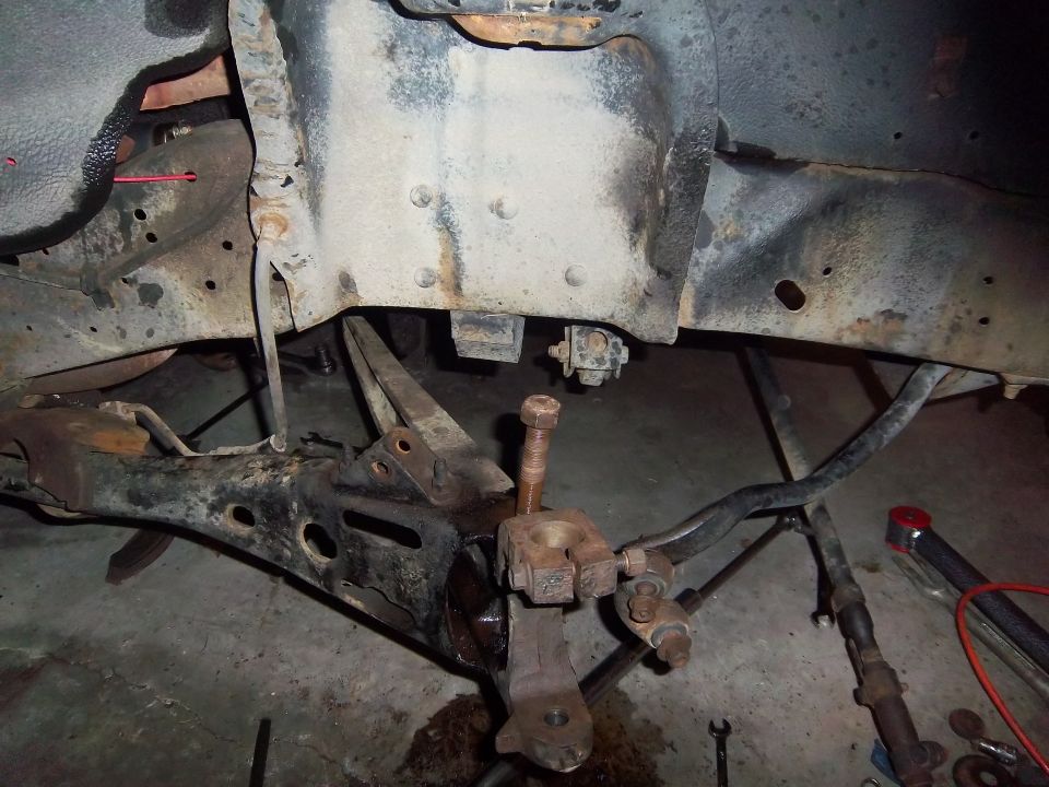Close-up of rusty truck suspension components, including control arms and steering linkage