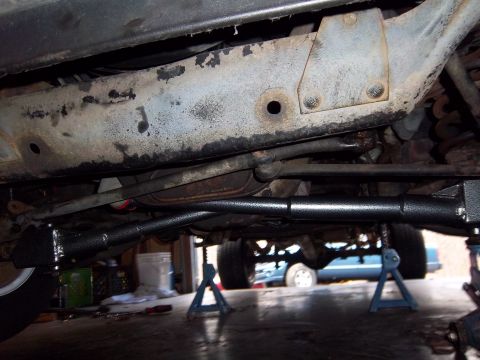 1989 Ford F-150 - The underside of a vehicle is shown, with a focus on the steering and frame components. A second vehicle is visible in the background.