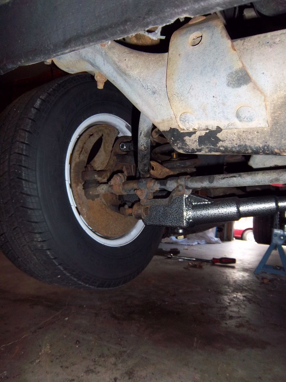 1989 Ford F-150 front suspension with tire, brake drum, and steering linkage visible