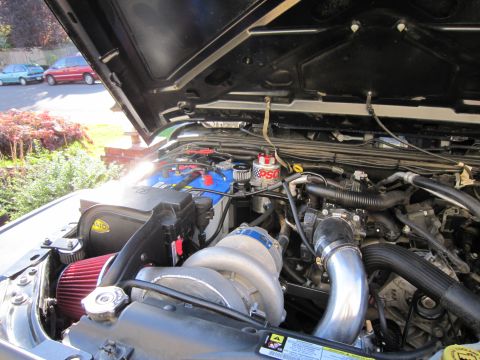 2008 Jeep Wrangler - The engine bay of a vehicle, a prominent supercharger and aftermarket air intake system.