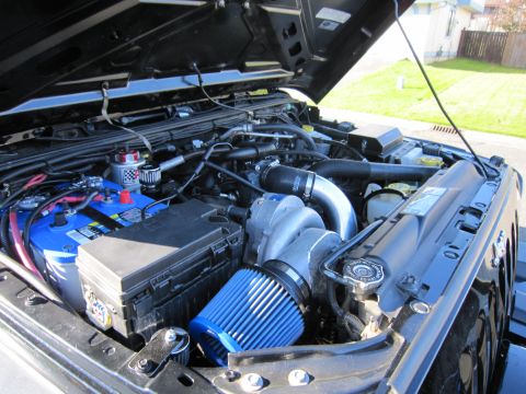 2008 Jeep Wrangler - Engine bay of a 2008 Jeep Wrangler showing a supercharger and custom air intake.