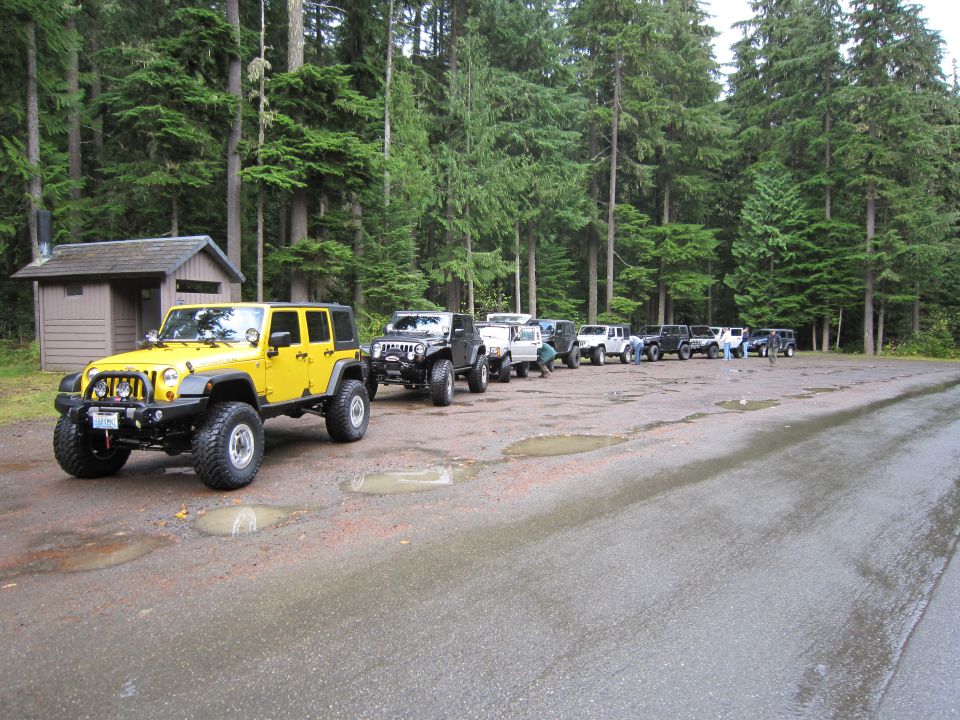 Yellow Jeep Wrangler parked in a line of off-road vehicles