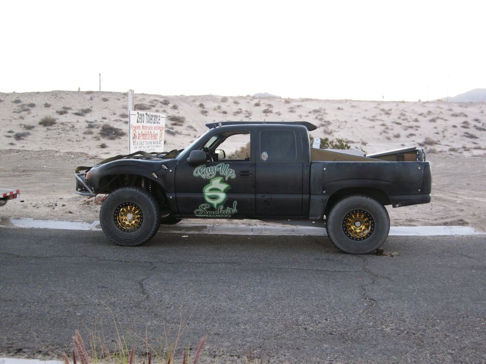 Black pickup truck with off-road tires and custom graphics on the side