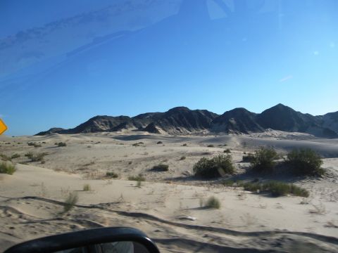 1986 Ford Bronco - View of a desert landscape with mountains in the background, seen from a vehicle.