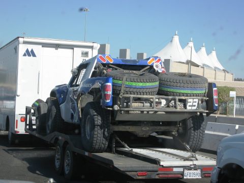 1986 Ford Bronco - Off-road truck being transported on a trailer, with a white trailer attached.