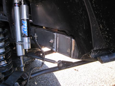 2008 Jeep Wrangler - Close-up view of modified Jeep suspension components, including Fox shocks and frame bracing.