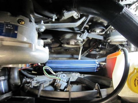 2008 Jeep Wrangler - Close-up view of an engine bay a supercharger and a blue aftermarket cooler. Readable text is visible on a plate attached to the supercharg…