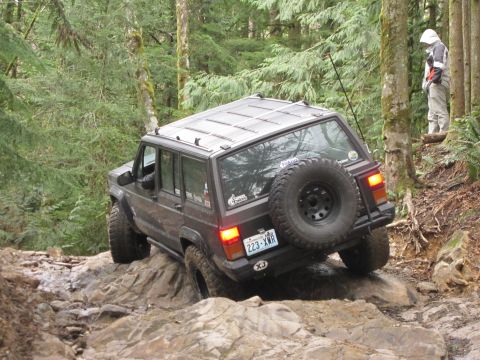 2008 Jeep Wrangler - A Jeep Cherokee XJ navigates a rocky off-road trail in a forest setting.