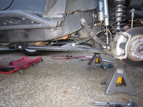 2008 Jeep Wrangler - The vehicle's front suspension is elevated on jack stands, revealing modifications and suspension components.