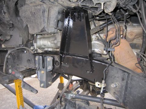 2008 Jeep Wrangler - Close-up view of a black suspension bracket assembly mounted to a vehicle's frame, likely for off-road modification.