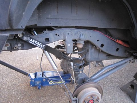 2008 Jeep Wrangler - Front suspension viewed from below with a Currie Antirock off-road sway bar and its arm linked to the axle, alongside a coil spring, shock…