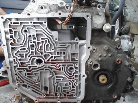1993 Ford Taurus - Automatic transmission valve body disassembled, revealing complex hydraulic channels and internal components.