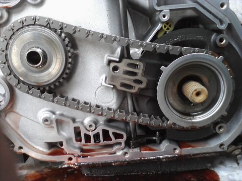 1993 Ford Taurus - Close-up of internal transmission components, showing a chain and gears with fluid residue.