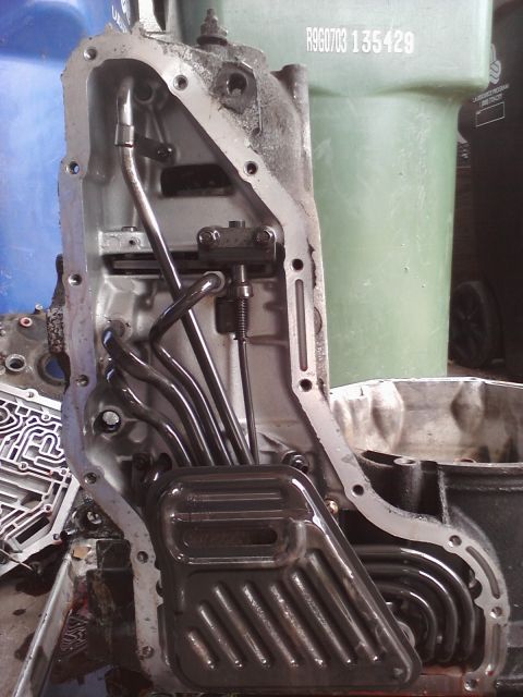 1993 Ford Taurus - The image shows the inside of a transmission pan, including the filter and fluid tubes.