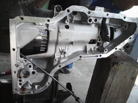 1993 Ford Taurus - Close-up of a transmission case, revealing internal gears and components. A metal rod is visible within the assembly.