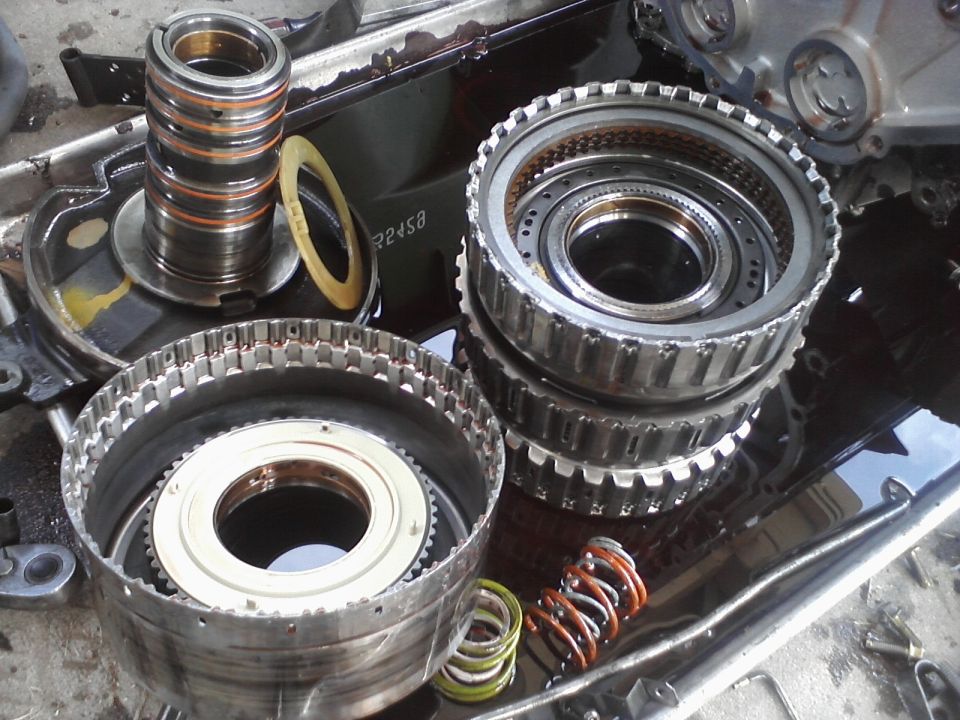Transmission components laid out, including gears, clutch packs, and springs