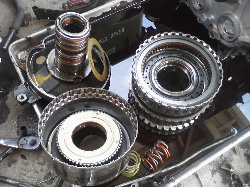 Disassembled automatic transmission clutch drums, servo piston and return springs on a bench