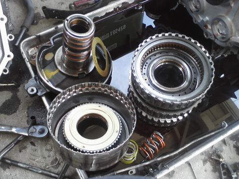 1993 Ford Taurus - Automatic transmission parts laid out on a surface, likely during a repair or rebuild process.