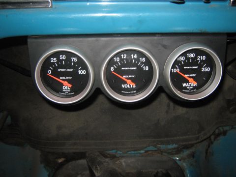 1972 Ford F-250 - Three aftermarket gauges are mounted in a panel, showing oil pressure, voltage, and water temperature readings.