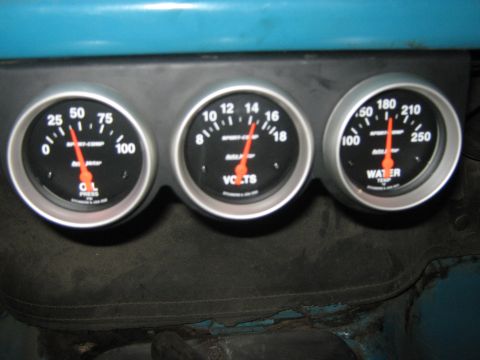 1972 Ford F-250 - Close-up of three automotive gauges showing oil pressure, voltage, and water temperature readings.