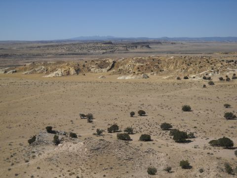 1986 Ford Bronco II - A lone SUV is visible in a vast desert landscape under a clear blue sky.