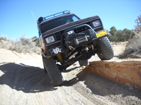 1986 Ford Bronco II - This 1986 Ford Bronco II navigates a challenging off-road obstacle on a sunny day.