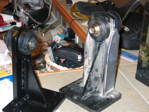 1984 Ford Bronco - Two metal suspension mounting brackets with rubber isolators are shown on a surface.