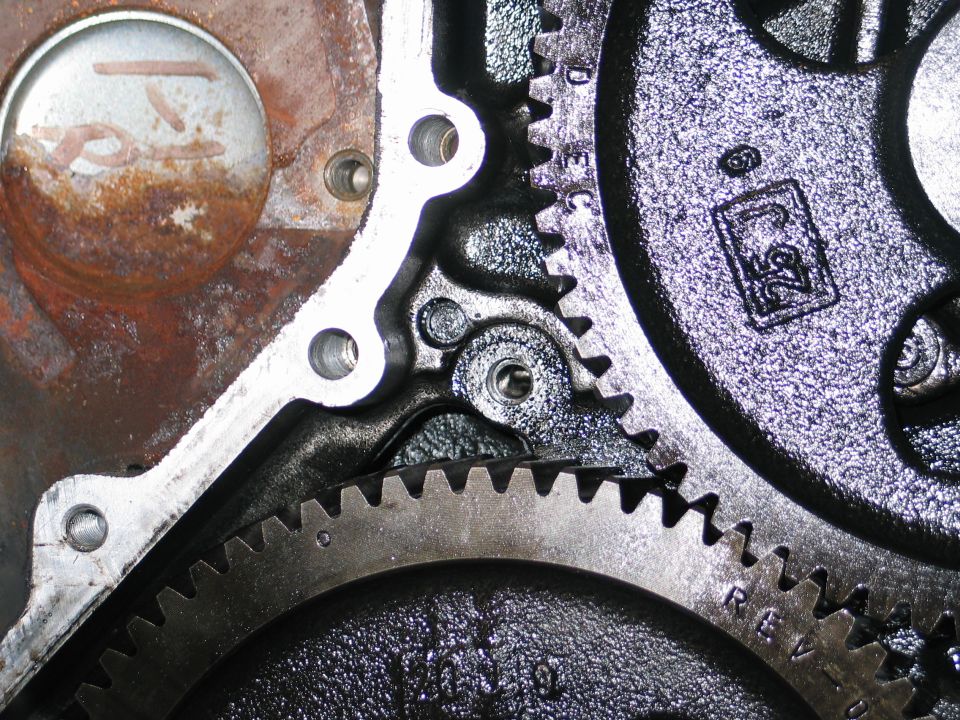Close-up of meshing engine gears, one with a "25" stamp inside a box