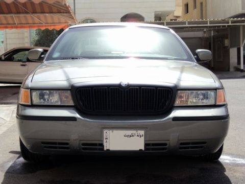 2001 Mercury Grand Marquis - A silver 2001 Mercury Grand Marquis is parked outside, with another car visible in the background.