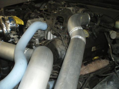 1998 Ford Crown Victoria - Custom intercooler piping installed in an engine bay, showing a supercharger and various hoses.