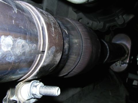 1990 Ford Bronco - Underside view of a catalytic converter and exhaust pipe assembly.